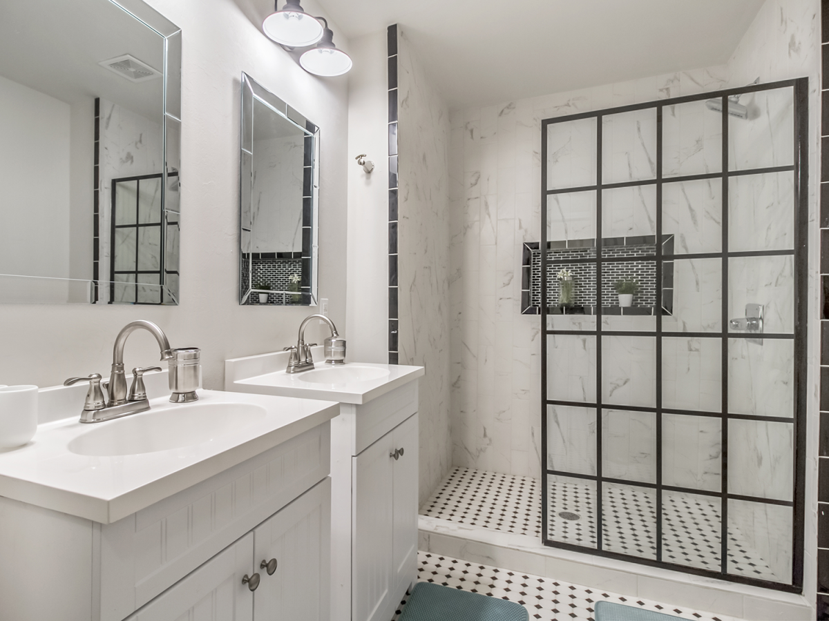 updated white bathroom with walk-in shower and dotted tile floors