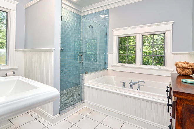 Built-in bathtub next to blue walk-in shower