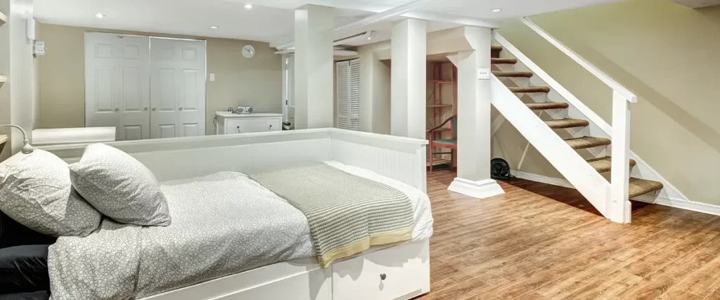 Cozy basement bedroom with wood floors, built-in storage bed, and soft ambient lighting