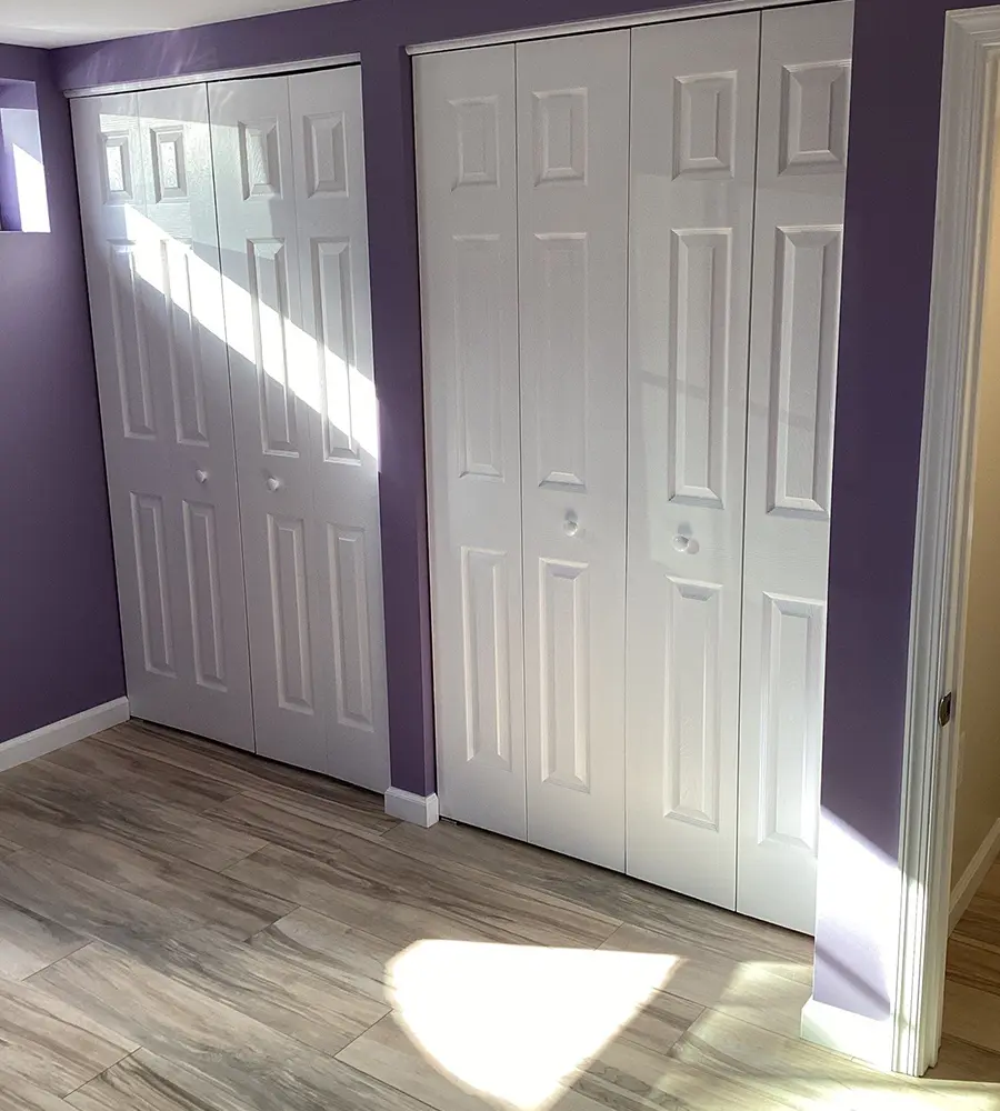 Purple accent wall in a remodeled bedroom with double closets