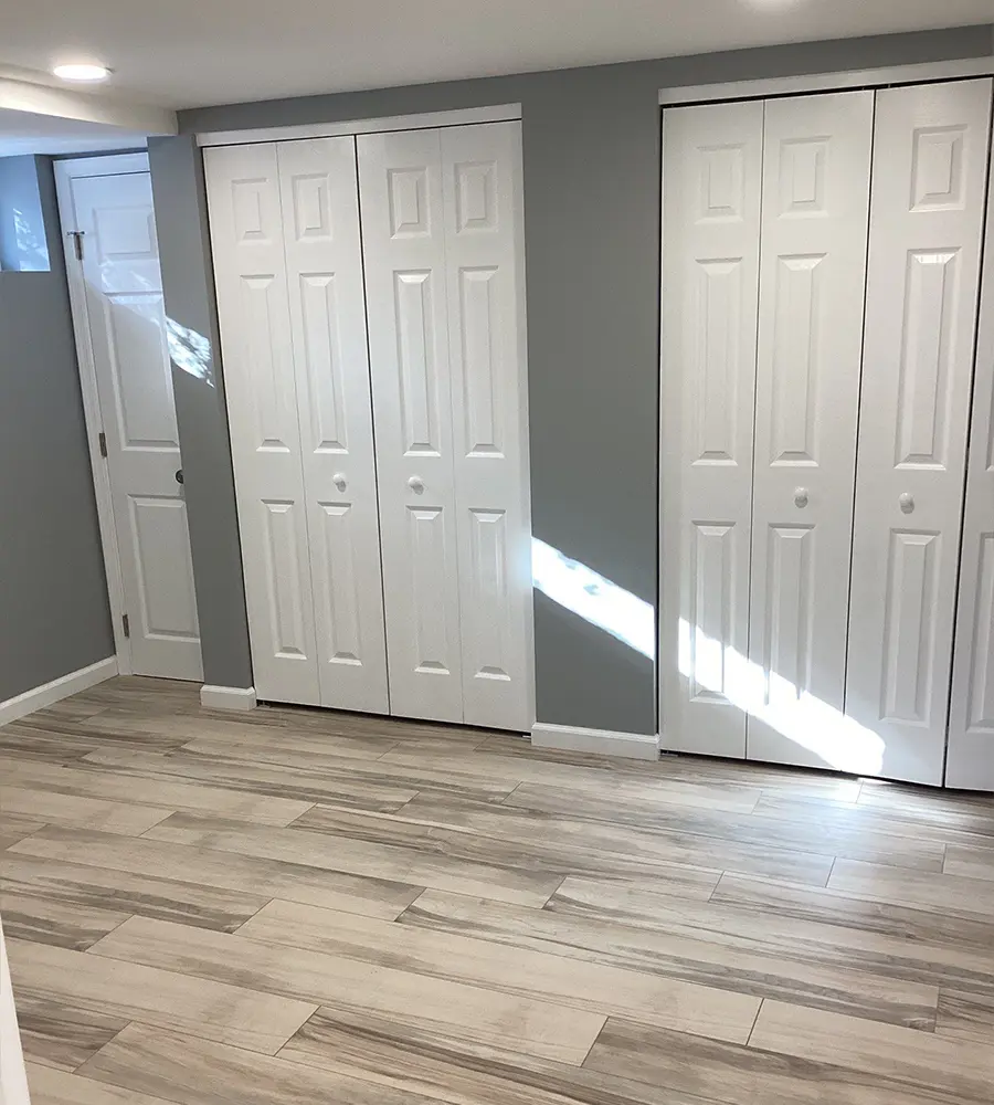 Finished bedroom with gray walls and white double closet doors