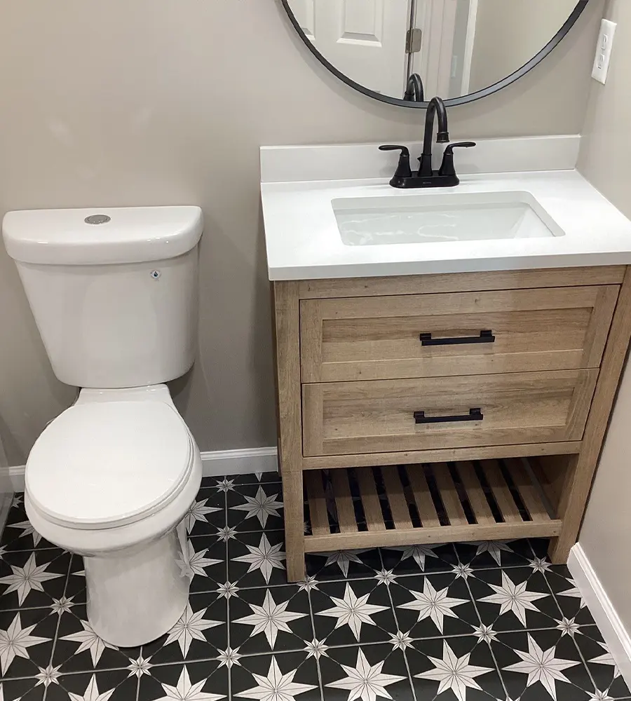 Compact bathroom with wood vanity and round mirror