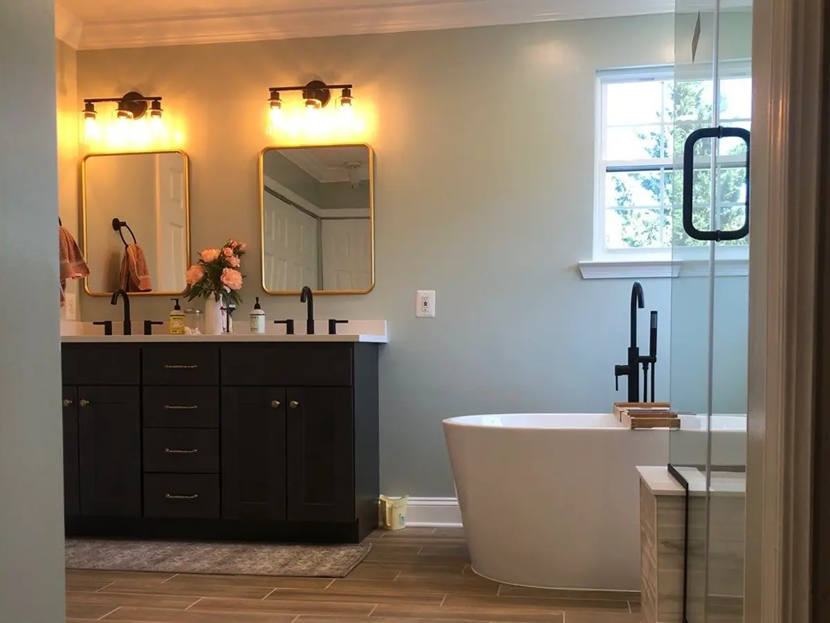 Modern bathroom with dual sink vanity, freestanding tub, and warm lighting