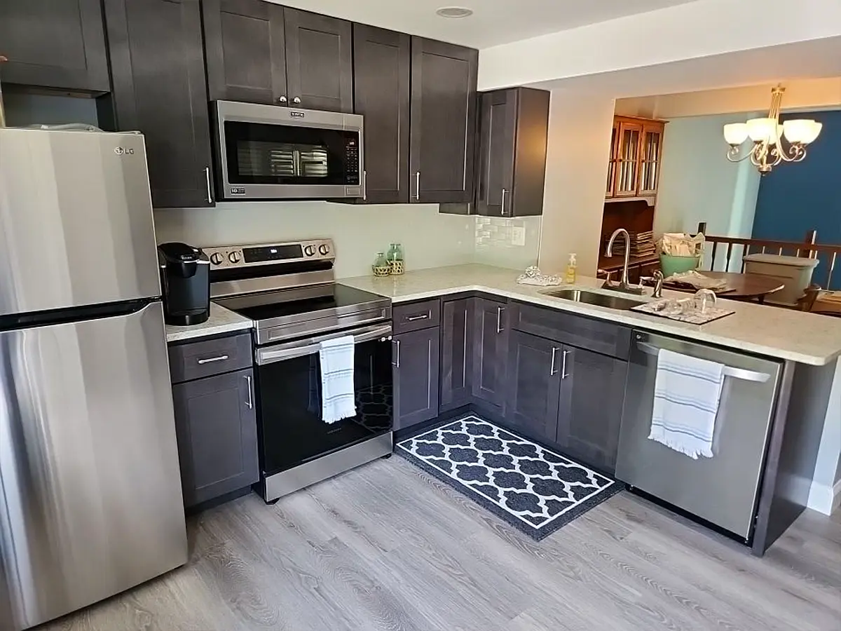 Contemporary kitchen with dark cabinets, stainless steel appliances, and quartz countertop