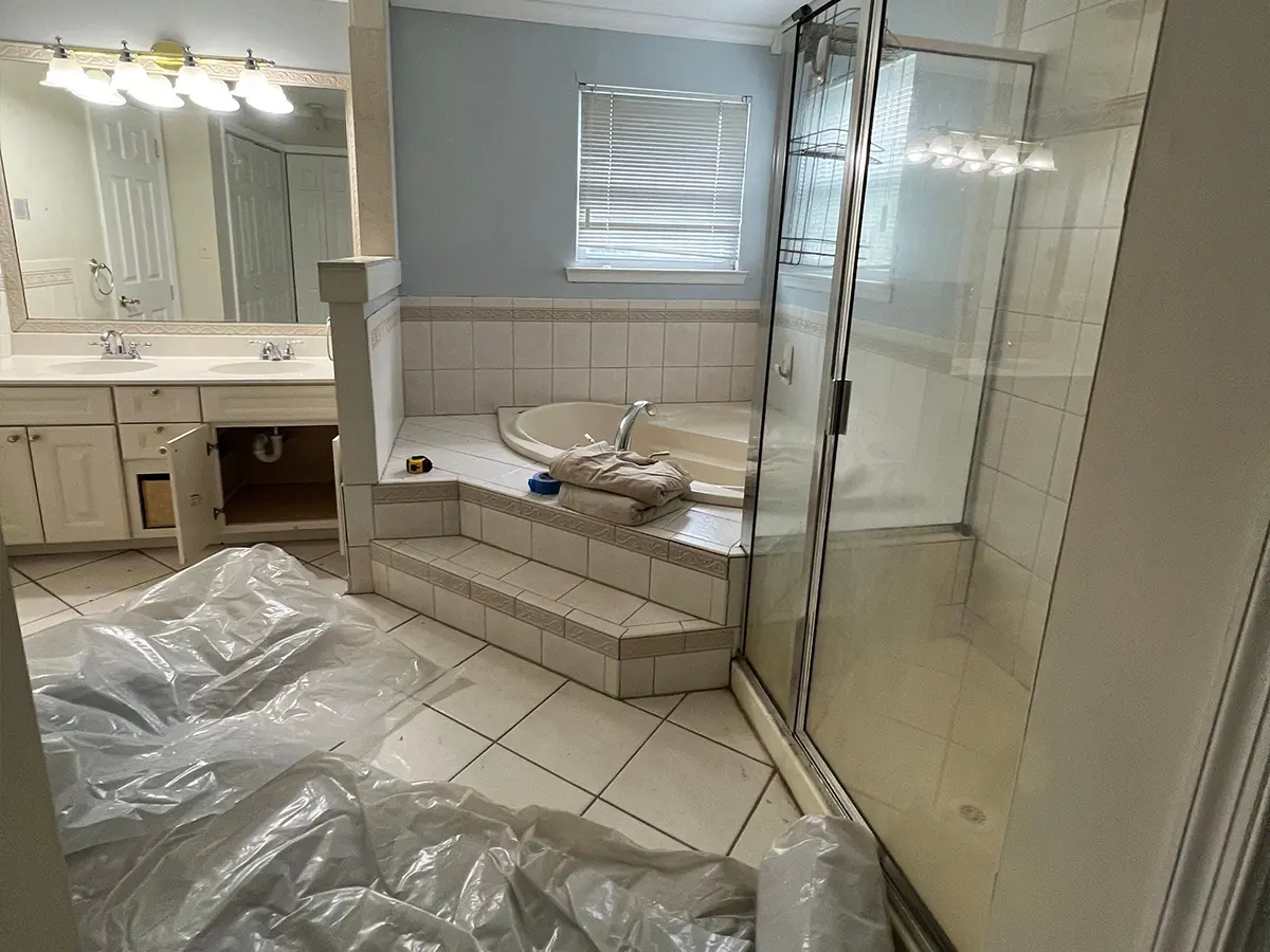 Large master bathroom with dated tile surfaces and open vanity cabinet