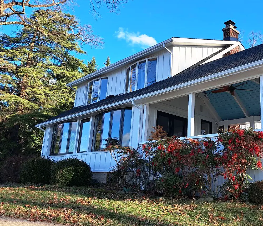 Exterior view of a remodeled white house with large windows