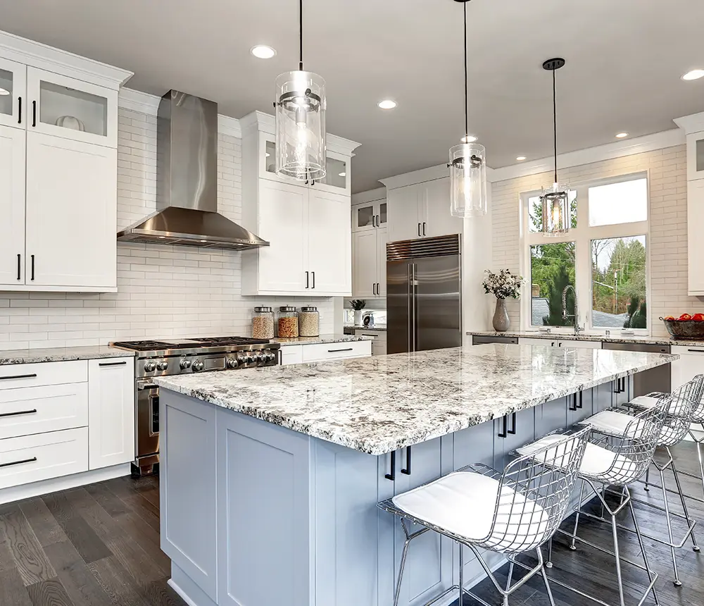 Luxury kitchen with white cabinetry, granite island, and pendant lighting
