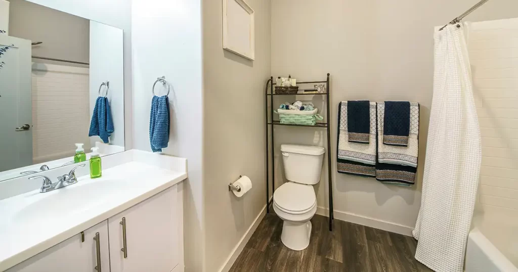 Bathroom storage rack over toilet with towels and toiletries