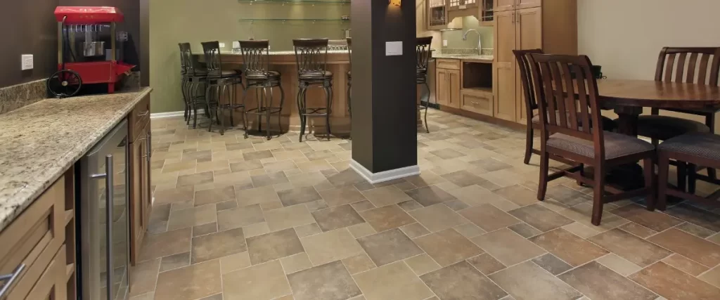 A basement kitchen featuring a bar and dining area with tile flooring