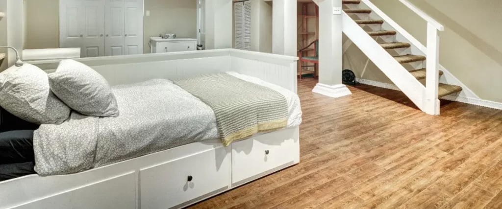 A cozy basement bedroom featuring a bed and hardwood flooring