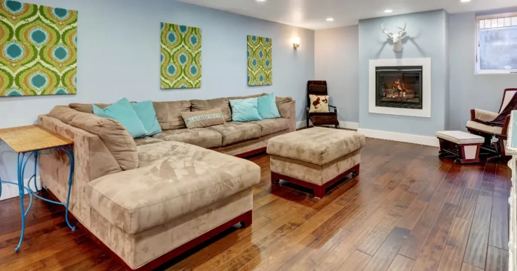 A cozy basement featuring hardwood flooring and a comfortable couch.