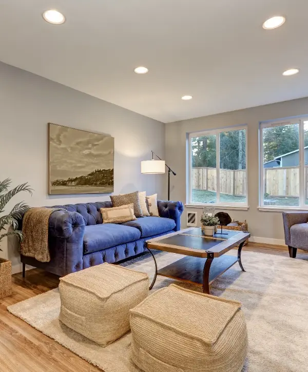 A cozy living room featuring blue furniture and a decorative rug on the floor.