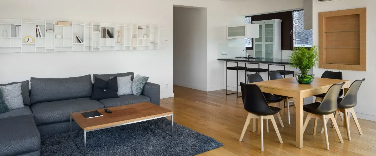 A modern apartment interior featuring a stylish couch, dining table, and chairs.