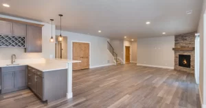 a finished basement living space with a kitchen area and a fireplace and a ceiling with recessed lighting