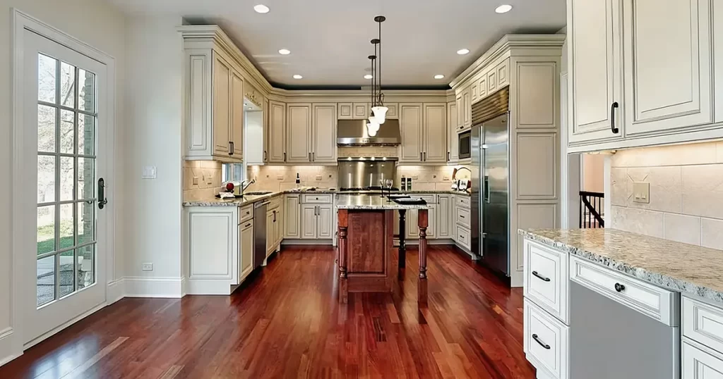 hardwood flooring in kitchen with white cabinets and center island