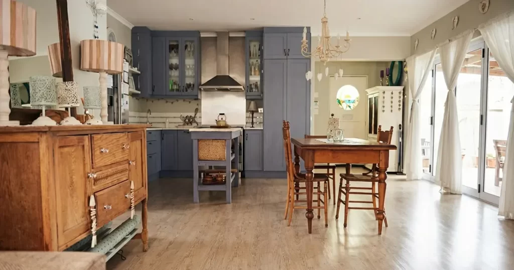 light wood flooring in kitchen with dining table and gray cabinets