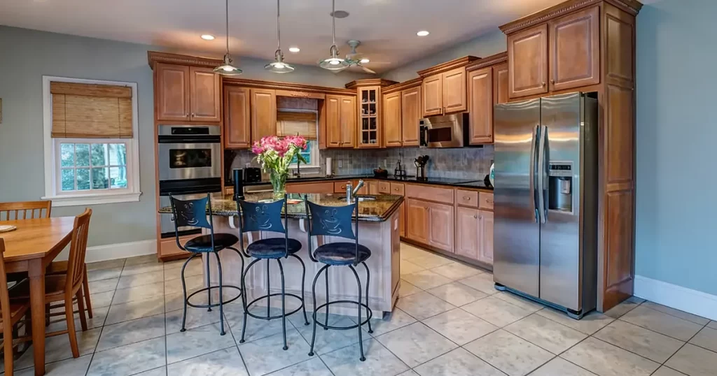 tile kitchen flooring with island seating and wood cabinets