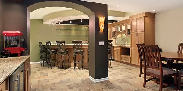 Basement bar and dining area with wood cabinets, tiled flooring, and built-in wet bar with barstools Basement bar and dining area with wood cabinets, tiled flooring, and built-in wet bar with barstools