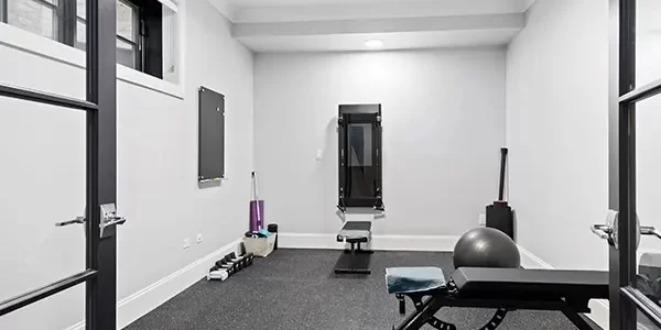 Home gym in finished basement with rubber flooring, workout bench, and fitness equipment Home gym in finished basement with rubber flooring, workout bench, and fitness equipment