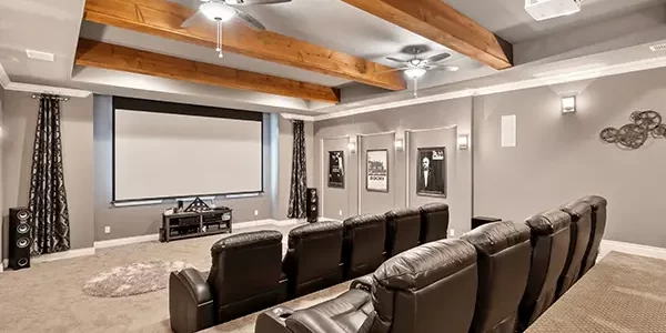 Home theater room with leather recliners, ceiling beams, and projector screen in finished basement media room Home theater room with leather recliners, ceiling beams, and projector screen in finished basement media room