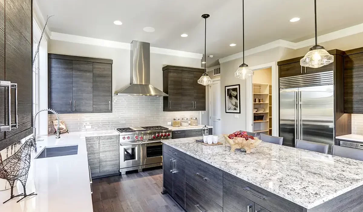 Spacious kitchen with dark cabinets, granite island, and pendant lights